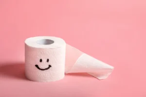 Toilet paper roll with smiley face symbolizing constipation relief