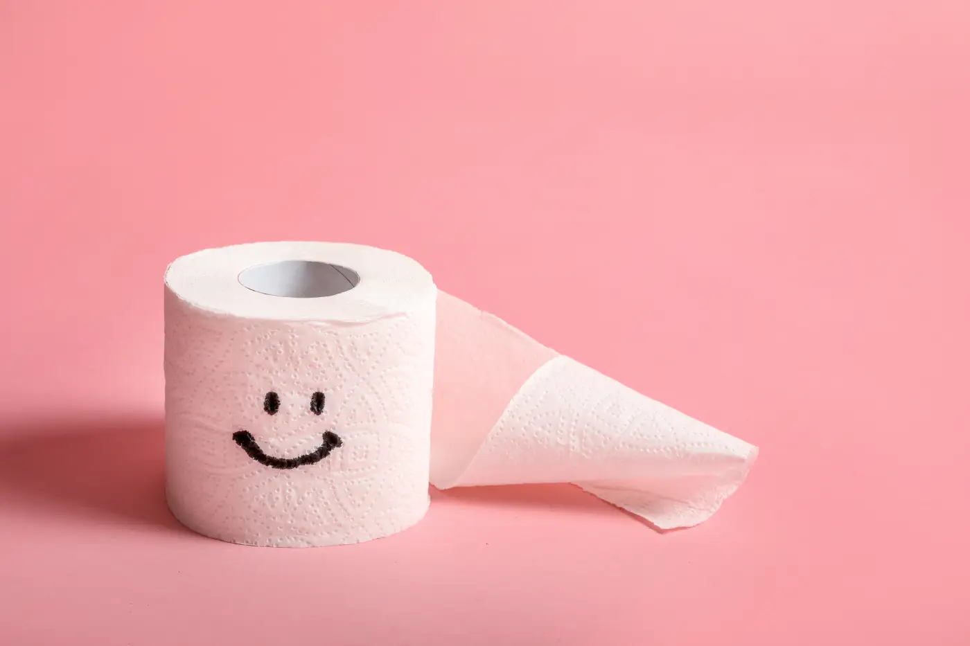 Toilet paper roll with smiley face symbolizing constipation relief